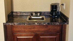 A kitchen with a granite countertop, a stainless steel sink, and a coffee maker. - The Inn at St George (St. George)