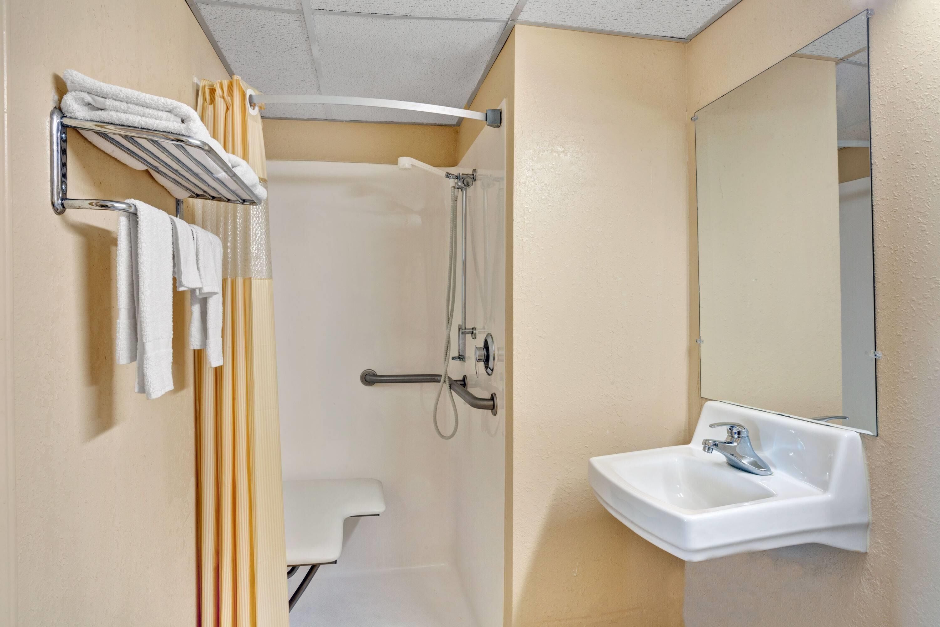 A bathroom with a shower, toilet, and sink.