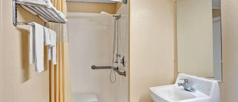 A bathroom with a shower, toilet, and sink.
