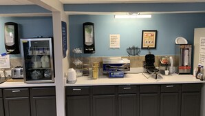 A breakfast area with a refrigerator, self-serve pancake station, and a coffee machine. - Days Inn by Wyndham Louisville Airport Fair and Expo Center (Louisville)