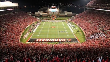 A football stadium filled with spectators, featuring a large "Cardinals" logo on the field.