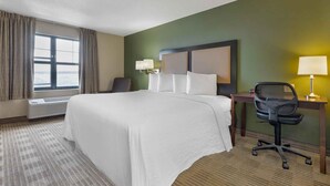 A hotel room with a large bed, a desk with a chair, a lamp, and a window with curtains. - Extended Stay America Suites Washington DC Springfield (Springfield)