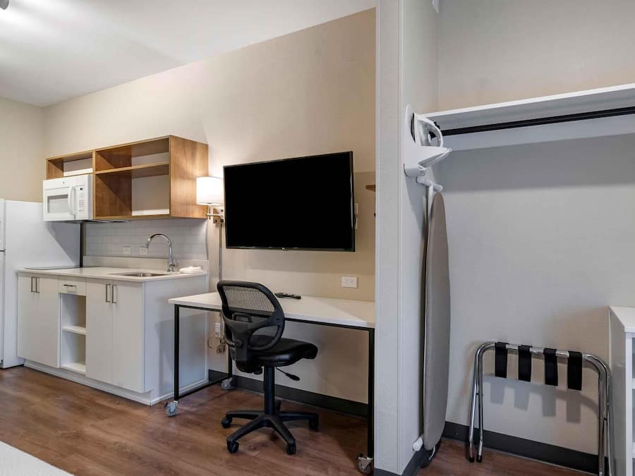 A compact kitchenette with a microwave, refrigerator, and sink.