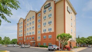 A multi-story hotel with a flat facade, multiple windows, and a parking lot with several cars. - Extended Stay America Suites Washington DC Centreville Manas (Centreville)