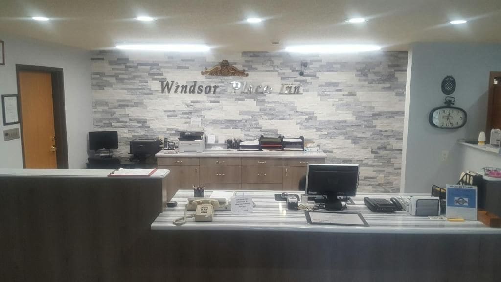 Una recepción con una placa, un reloj y un monitor de computadora.