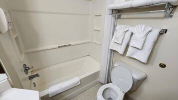 A bathroom with a bathtub, toilet, and towel rack.