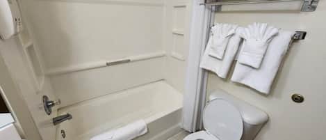 A bathroom with a bathtub, toilet, and towel rack.