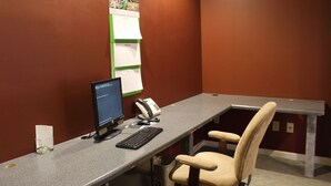 A small office with a desk, computer, telephone, and a chair. - Hotel Chester (Starkville)