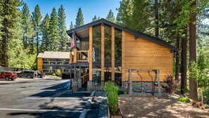 A lodge with a wooden exterior, stone accents, and a parking area.