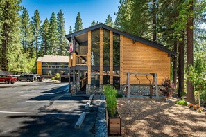 A lodge with a wooden exterior, stone accents, and a parking area.