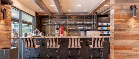 Eine moderne Bar mit Holzelementen, Barhocker und einer Glasvitrine.