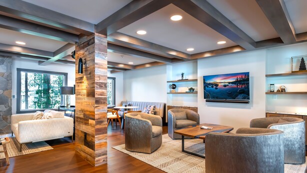 A modern living room with wooden floors, a stone accent wall, and a large painting.