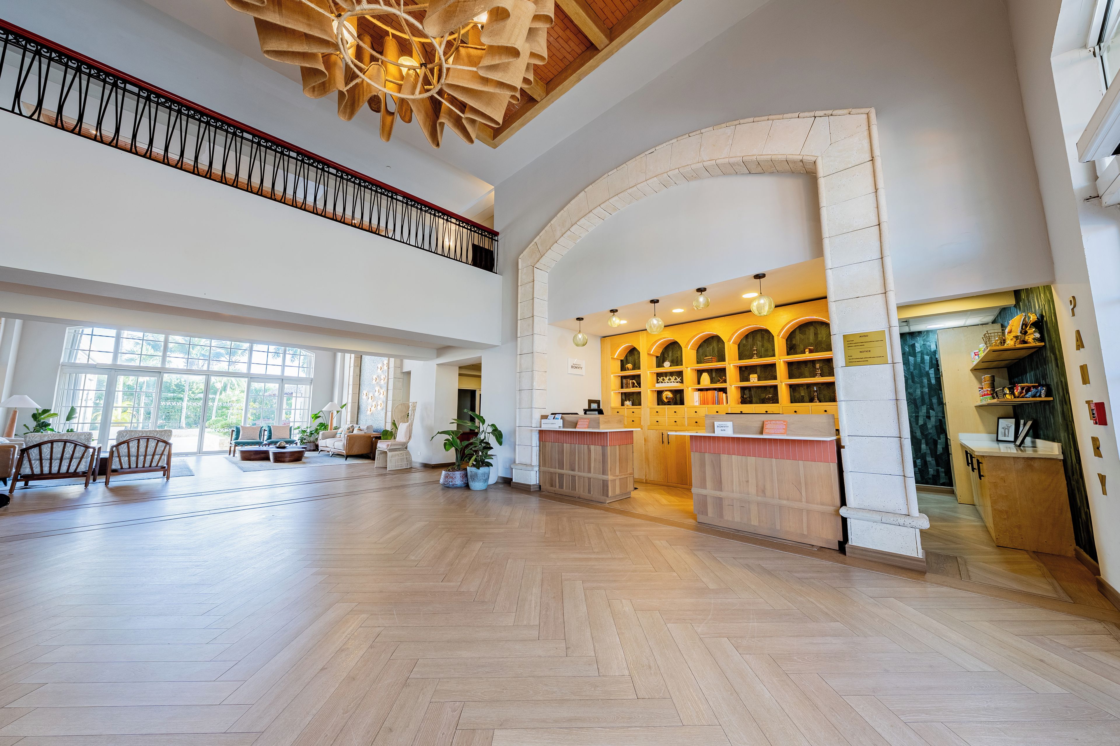 Un hall d’entrée spacieux avec un plancher en bois, un comptoir d’accueil et un escalier.