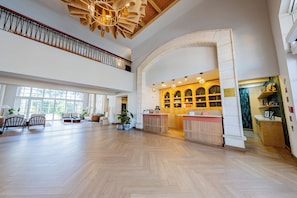 A spacious lobby with a wooden floor, a reception desk, and a staircase. - Four Points by Sheraton Santo Domingo (Boca Chica)