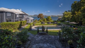 A house with a swimming pool, a stone pathway, and a view of the lake.