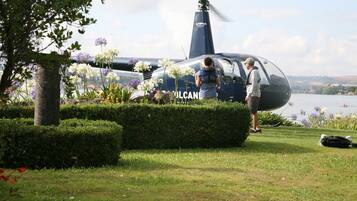 Ein Hubschrauber mit dem Schriftzug "VULCAN" an der Seite, geparkt in der Nähe eines Sees.
