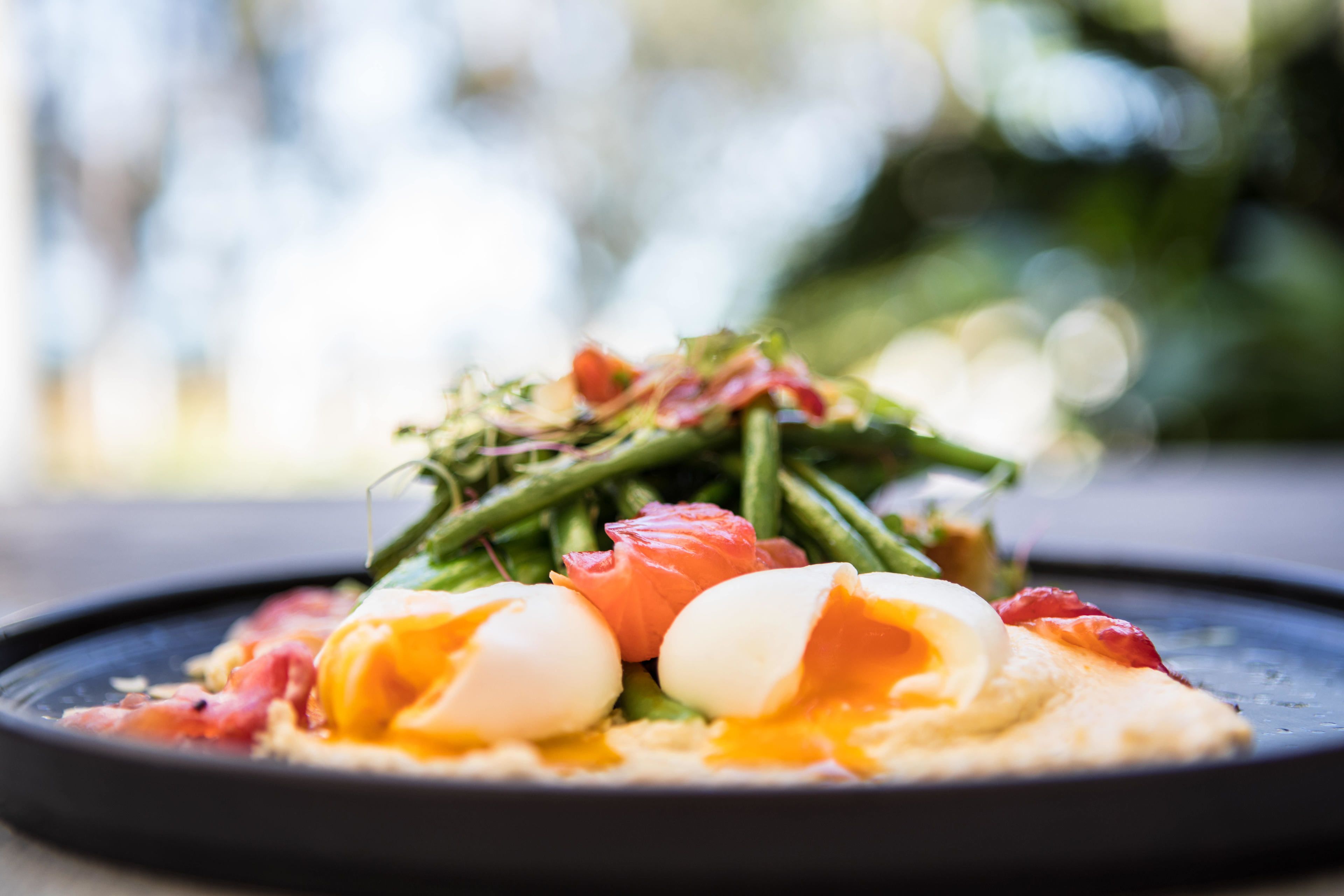 A plate of food with eggs, green beans, and tomatoes.