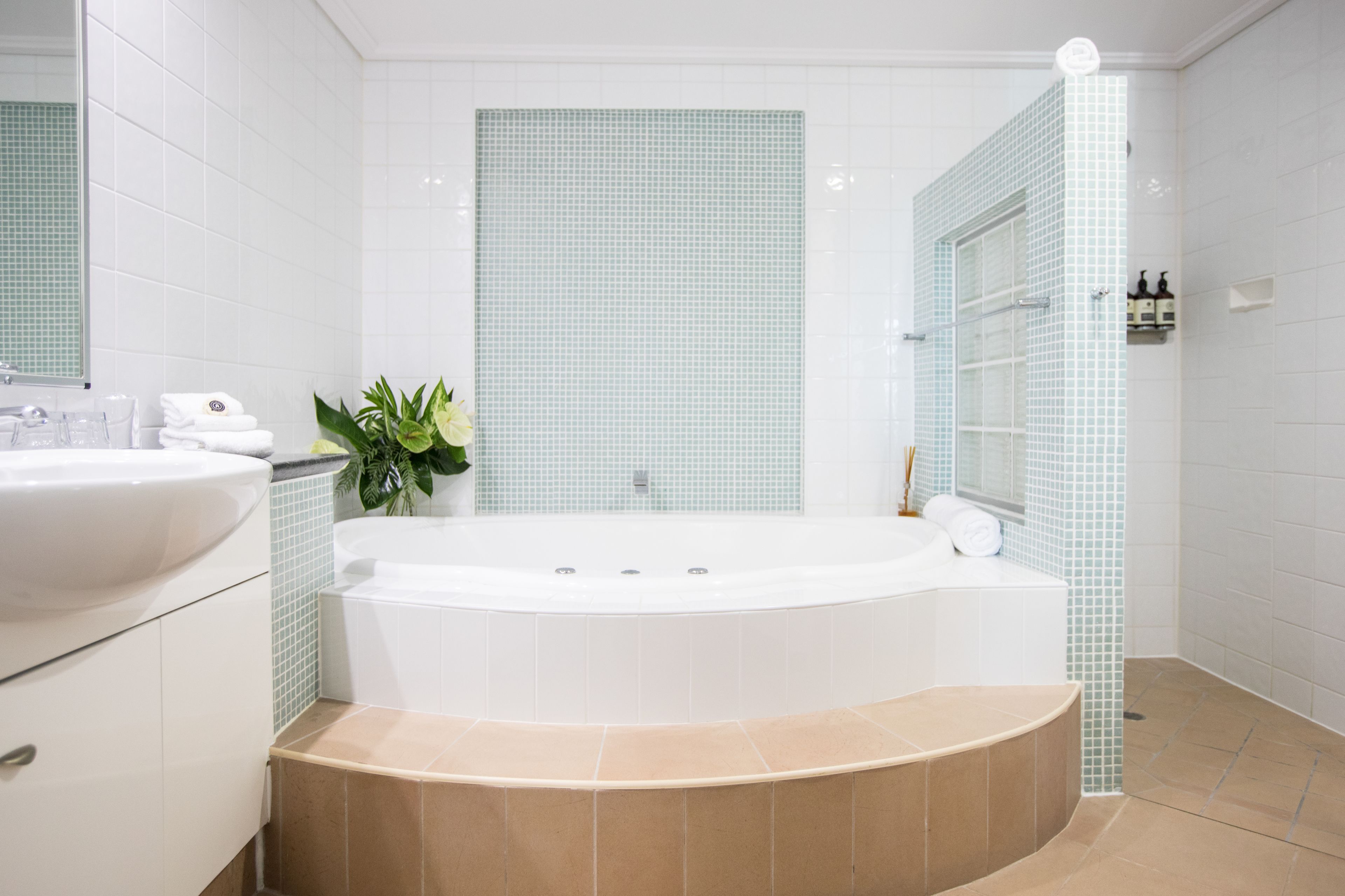 A modern bathroom with a freestanding bathtub, a sink, and a mirror.