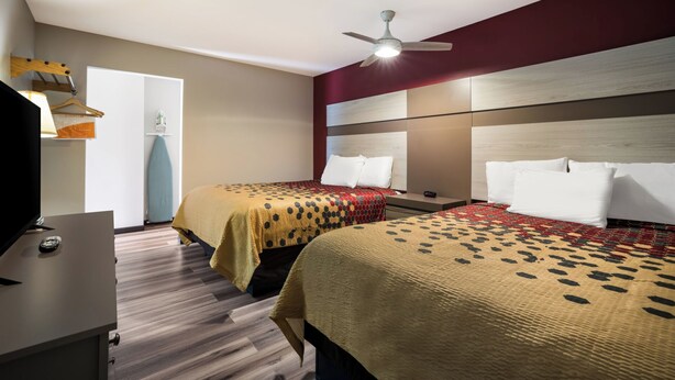 A hotel room with two beds, a ceiling fan, a TV, and a desk. - Econo Lodge Inn & Suites Canandaigua - Fingers Lake Area (Canandaigua)