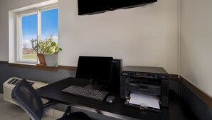 A home office setup with a desk, computer, printer, and a potted plant by a window. - Econo Lodge Inn & Suites Canandaigua - Fingers Lake Area (Canandaigua)
