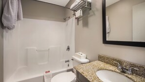 A bathroom with a bathtub, toilet, sink, and a towel rack. - Econo Lodge Inn & Suites Canandaigua - Fingers Lake Area (Canandaigua)