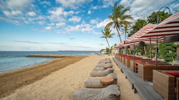 On the beach, white sand, sun loungers, beach umbrellas