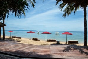 On the beach, white sand, sun loungers, beach umbrellas