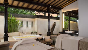Uma área de spa com uma banheira grande, uma mesa de massagem e um espaço de estar com vista para o jardim.