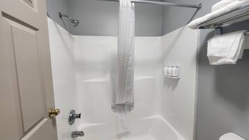 Een badkamer met een douche, een bad, een toilet en een handdoekrek.