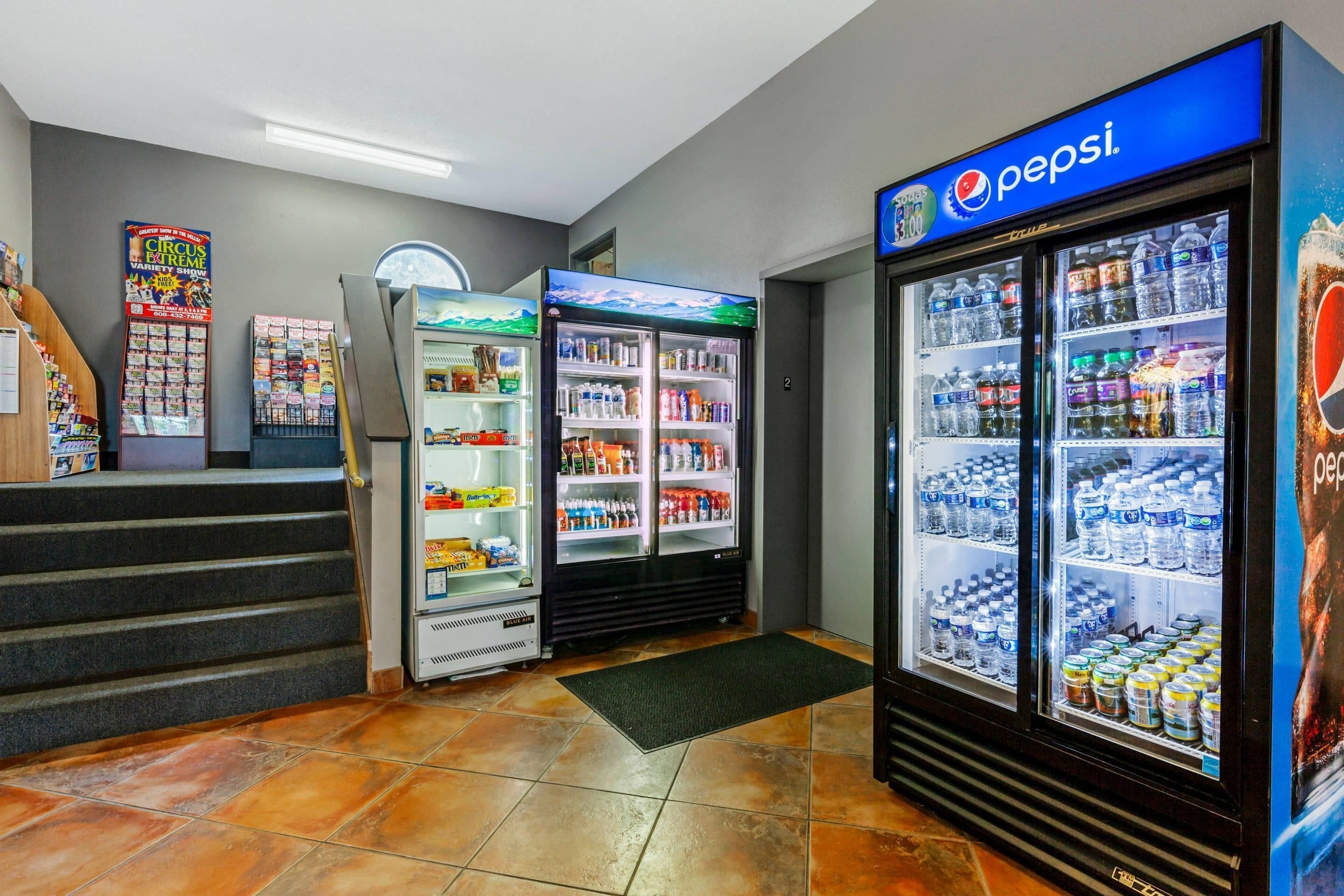 Een automaatruimte met Pepsi-koelkasten en een tijdschriftrek.