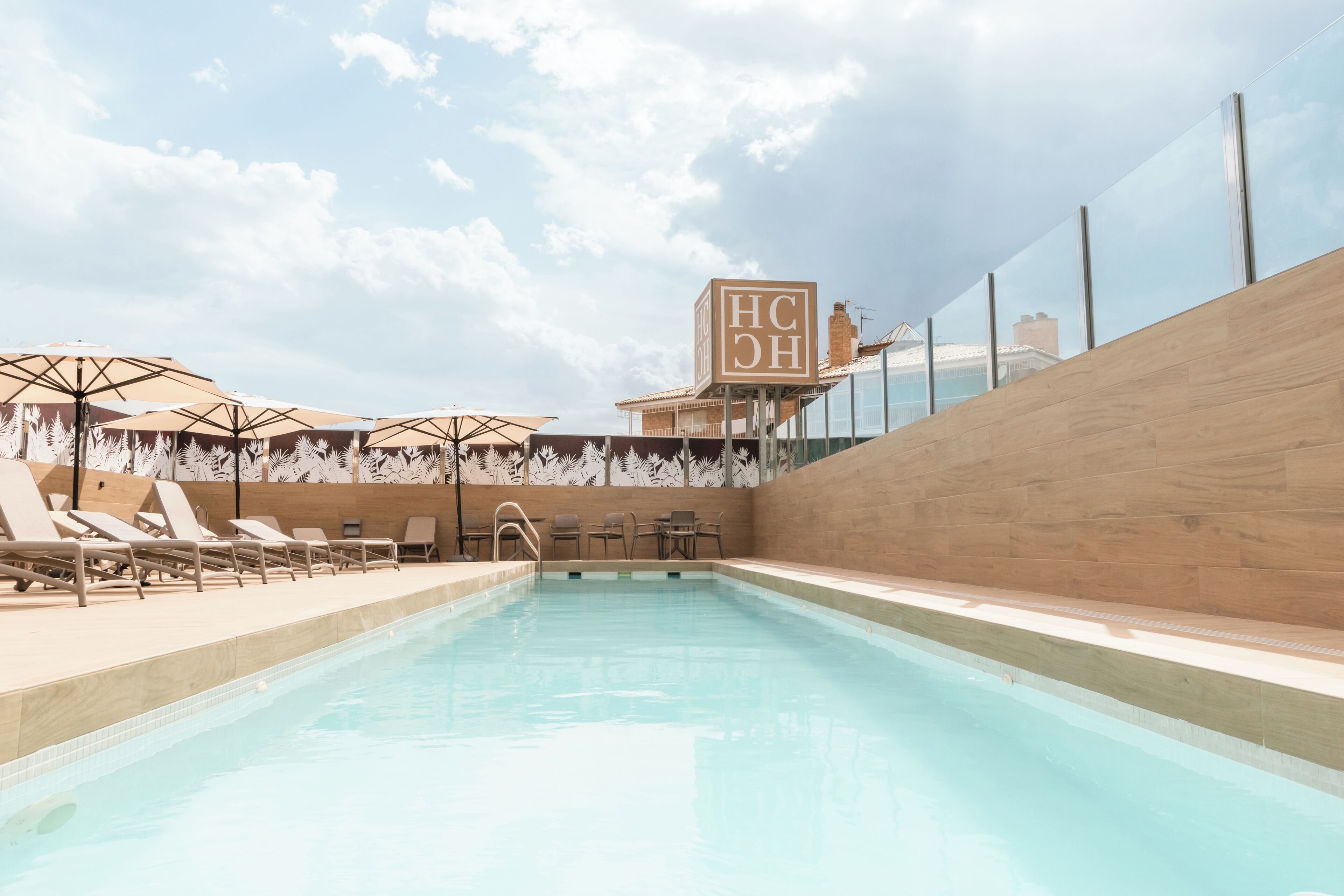 Una piscina al aire libre, sillones reclinables de piscina