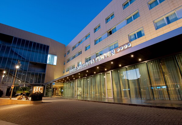 A hotel with a modern facade, large glass windows, and a prominent 'HC' sign. - Hotel Andalucia Center (Granada)