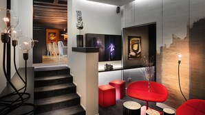 Un interior moderno con una escalera, asientos rojos y obras de arte en las paredes.