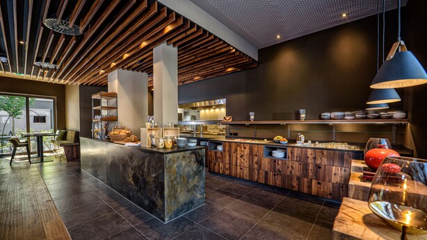Een moderne keuken met een centraal eiland, houten kastjes en een groot raam.