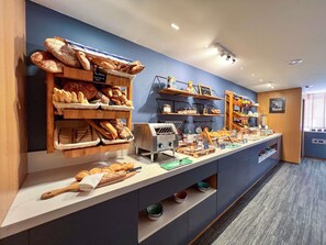 A buffet area with various food items and a coffee machine.