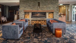 A modern living room with a stone fireplace, sofas, and a coffee table.