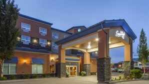 A hotel entrance with a covered walkway, a sign reading "Smith's", and a parking area visible in the background. - Best Western Cold Lake Inn (Cold Lake)