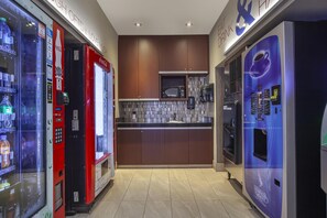 A modern kitchen with a microwave, a coffee machine, and vending machines. - Best Western Cold Lake Inn (Cold Lake)
