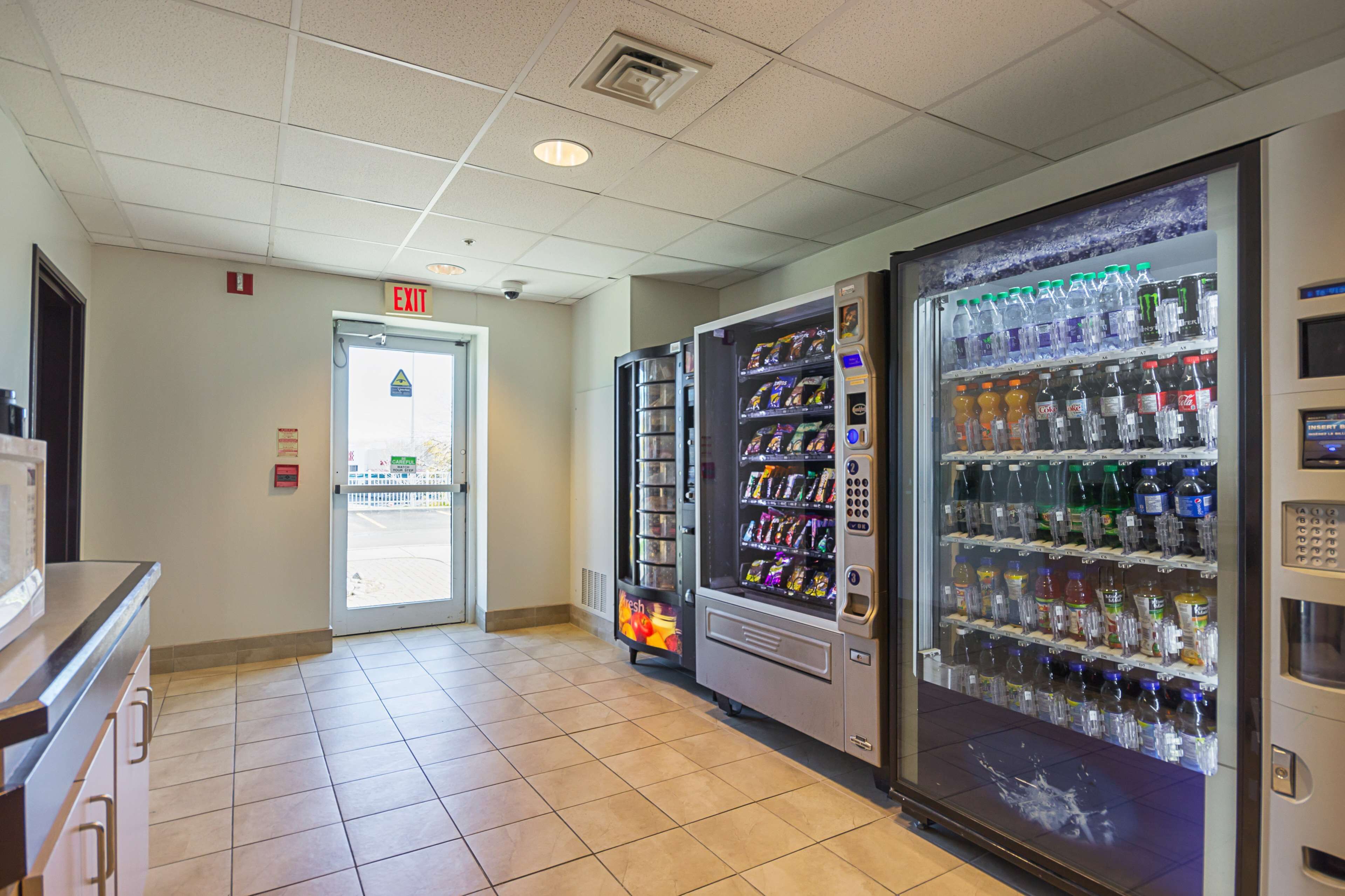 A hallway with vending machines and an exit door.
