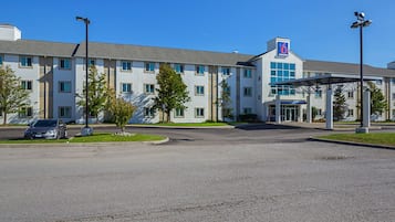 A multi-story hotel with a covered entrance and a parking lot.