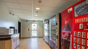 A corridor with a microwave, refrigerator, and vending machines. - Motel 6 Whitby, ON - Toronto East (Whitby)