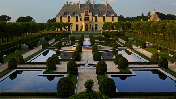 A large, historic building with a symmetrical garden featuring geometrically shaped ponds and neatly trimmed hedges. - Oheka Castle Hotel & Estate (Huntington)