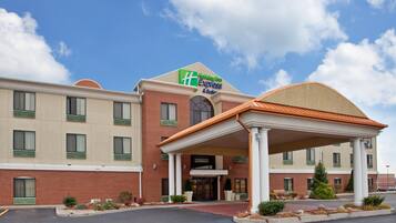 A Holiday Inn Express hotel with a brick facade, a covered entrance, and a clear sky.