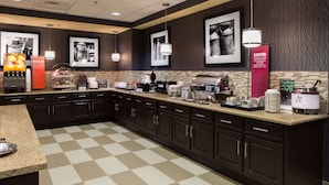 A modern kitchen with a checkered floor, dark cabinetry, and various appliances including a coffee machine and a toaster. - Hampton Inn by Hilton Troy (Troy)