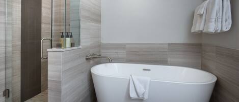 A modern bathroom with a freestanding bathtub, a glass shower enclosure, and a towel rack.