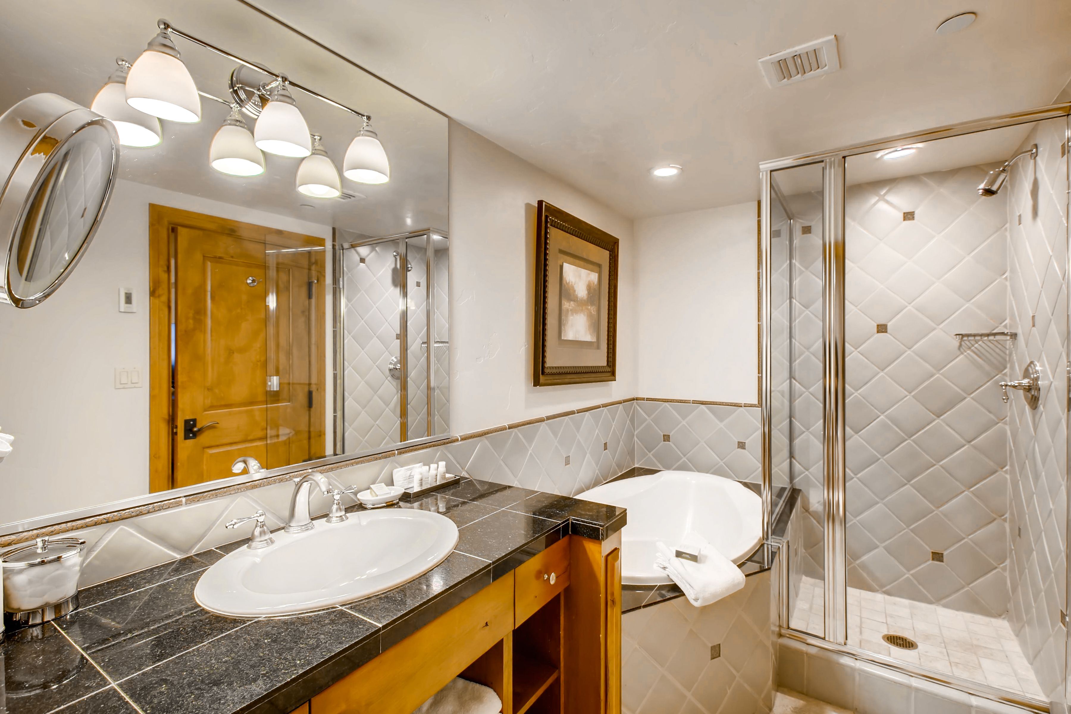 A bathroom with a double sink, a large mirror, and a glass-enclosed shower.