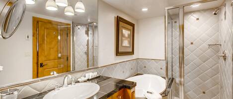 A bathroom with a double sink, a large mirror, and a glass-enclosed shower.