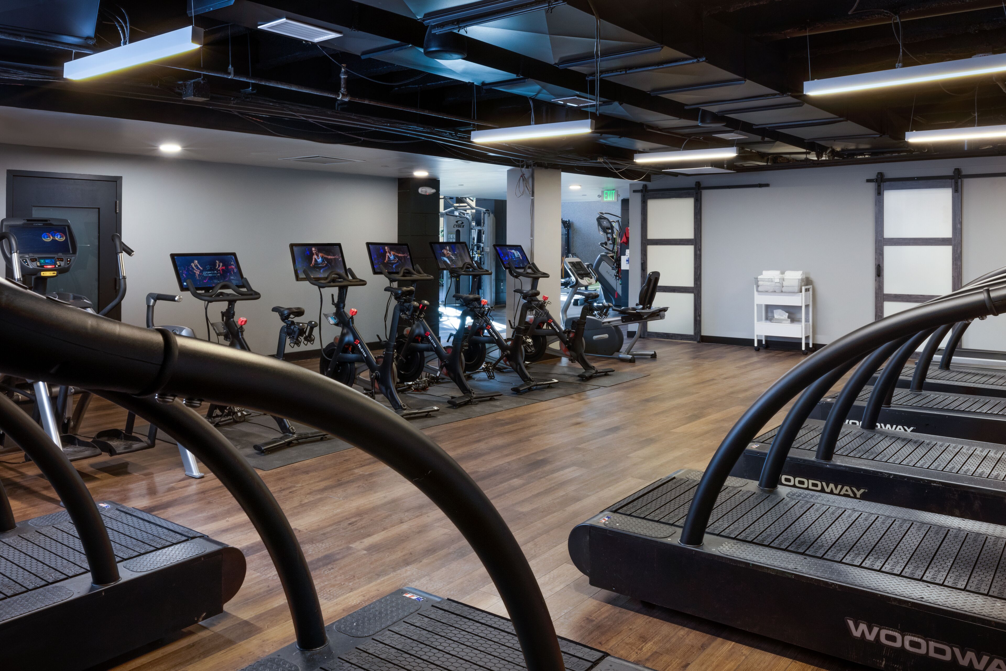 A gym with treadmills, stationary bikes, and elliptical machines.