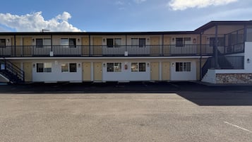 A motel with a two-story structure, a covered outdoor area, and a parking lot.