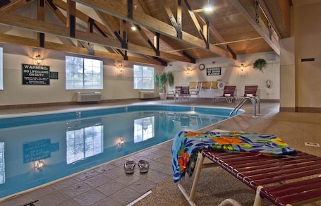 Una piscina techada, sillones reclinables de piscina